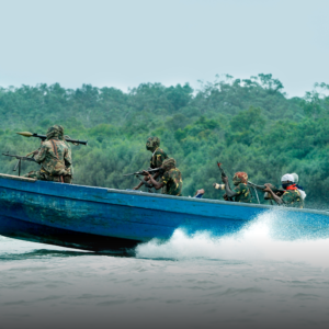 West African armed pirates on blue skiff in the Gulf of Guinea.